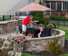 A family enjoys a patio with attached BBQ island.