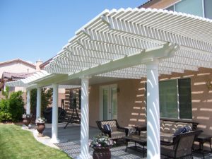 Backyard view of a home that has a pergola built into the patio.