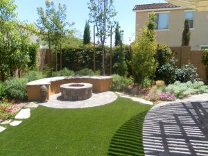 Picture of a backyard with a firepit, seating, and landscaping.
