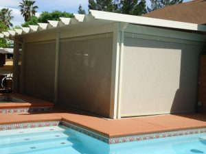 Picture of retractable screens on a patio next to a pool.