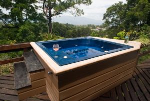 A beautiful custom hot tub on a deck with the view of a valley